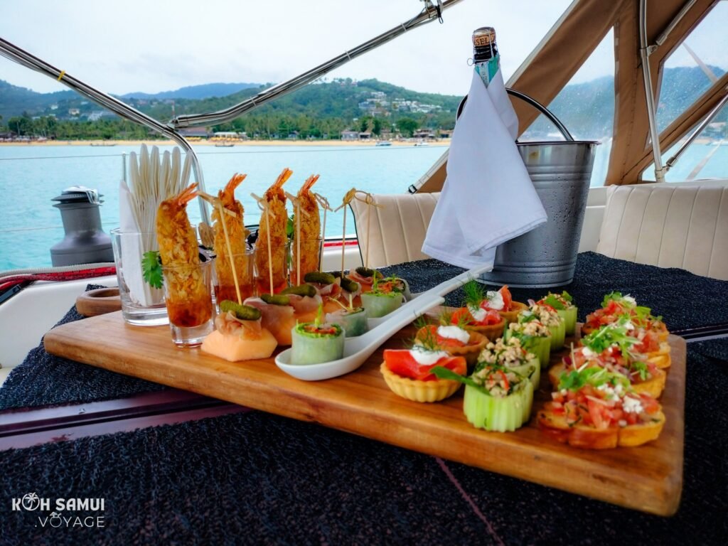 Champagne aperitif with delicacies from the chef aboard the luxury sailboat Aello Yachting in Koh Samui, during a tour of the islands.